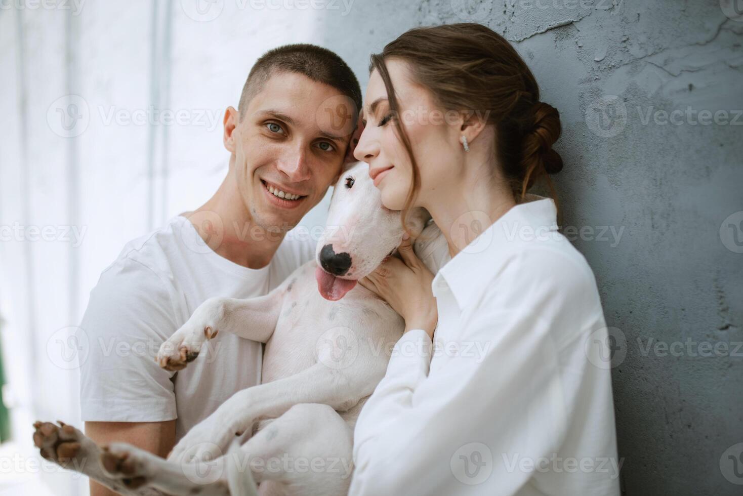 jovem casal cara e menina dentro uma brilhante quarto jogando com animal foto