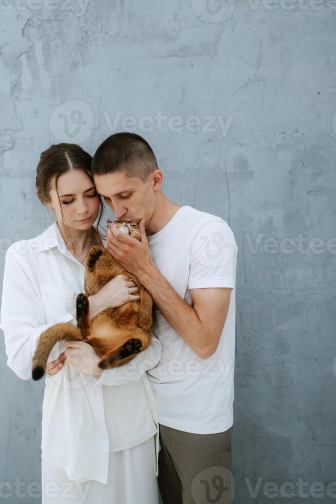 jovem casal cara e menina dentro uma brilhante quarto jogando com animais de estimação foto