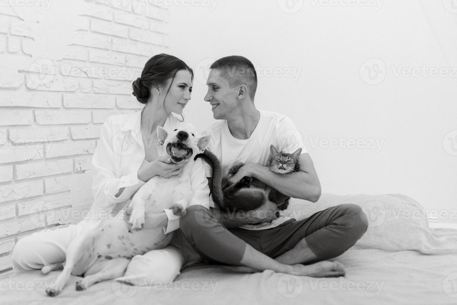 jovem casal cara e menina dentro uma brilhante quarto jogando com animais de estimação foto