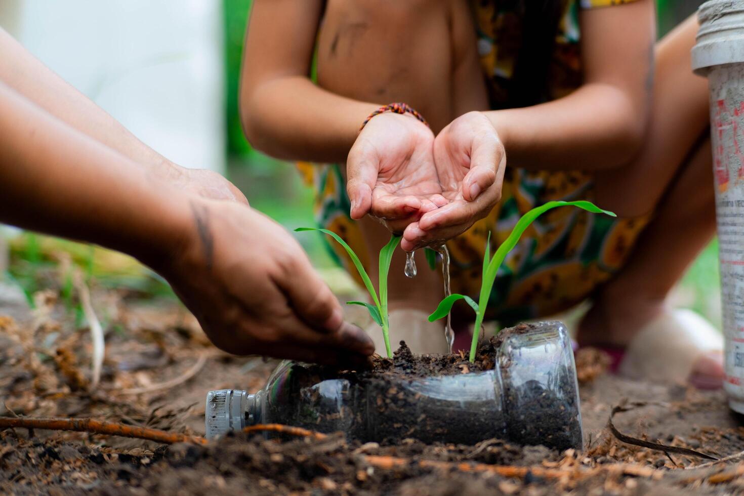 pequeno menina e mãe crescer plantas dentro panelas a partir de reciclado água garrafas dentro a quintal. reciclar água garrafa Panela, jardinagem Atividades para crianças. reciclando do plástico desperdício foto