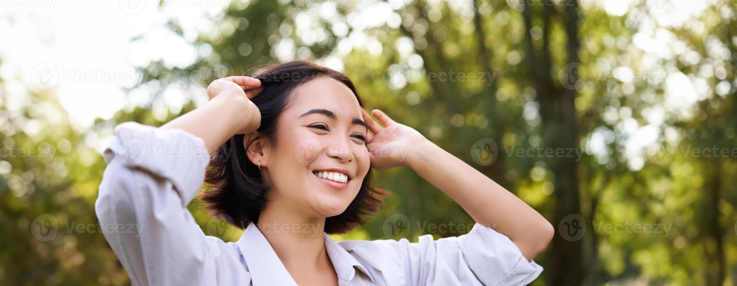 genuíno pessoas. retrato do ásia mulher rindo e sorridente, caminhando dentro parque, sentindo-me alegria e positividade foto