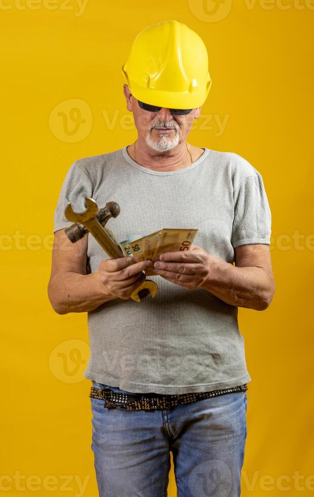 trabalhador com capacete é contando ganhou euro notas em amarelo fundo foto