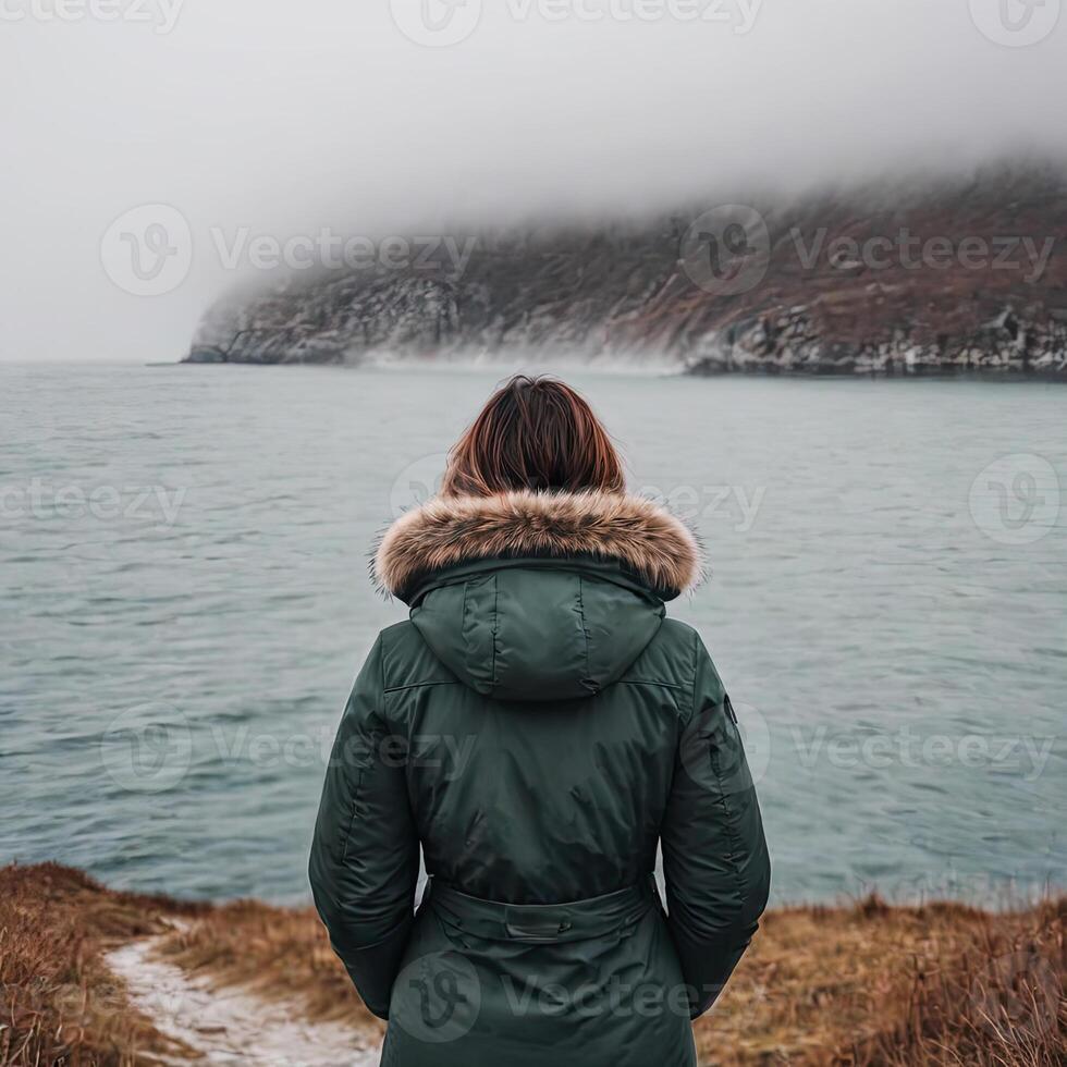 ai gerado sozinho mulher olhando às a mar em nebuloso dia foto