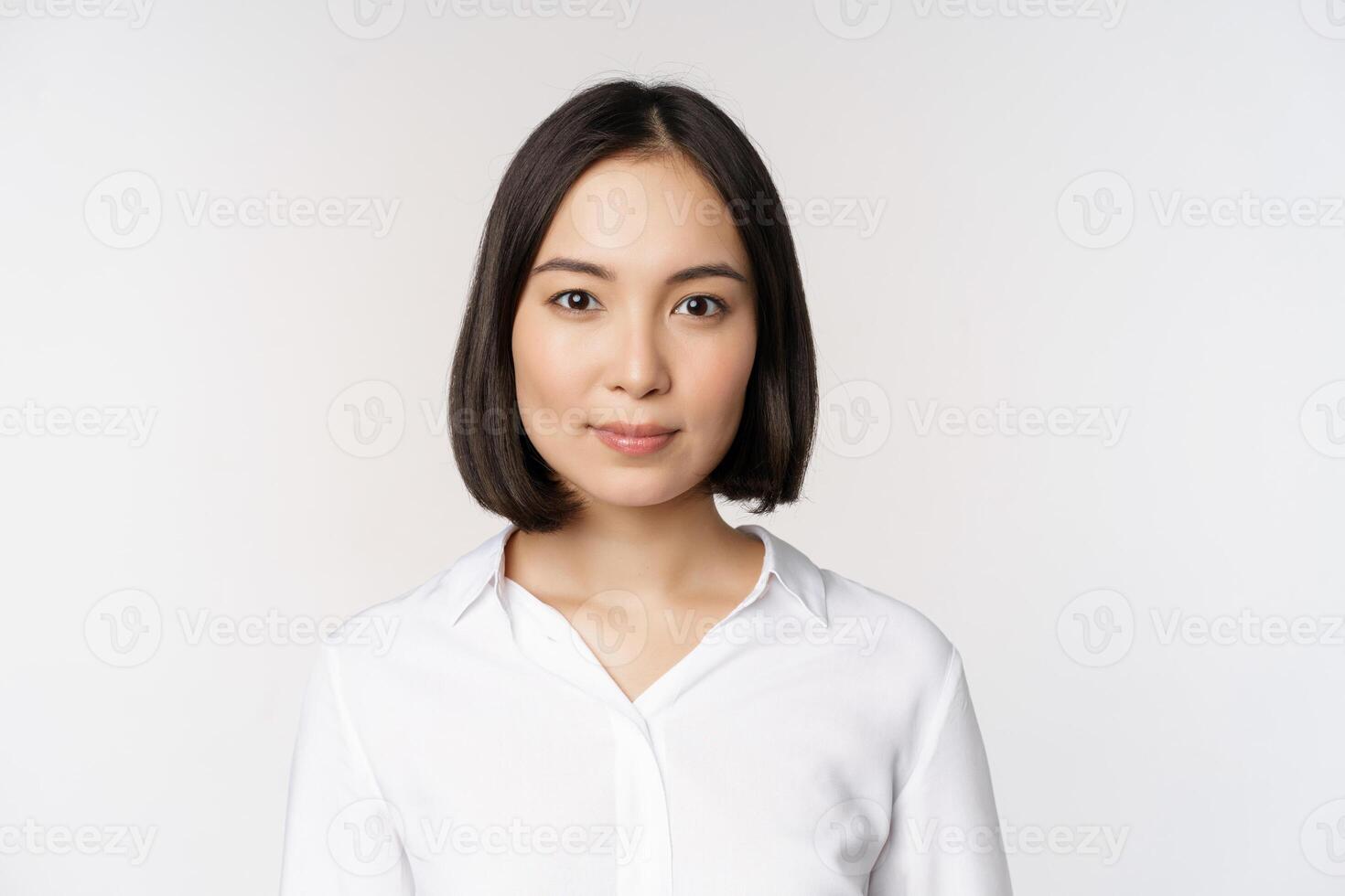 fechar acima retrato do coreano jovem ásia mulher, profissional, olhando confiante e assertivo às Câmera, branco fundo foto