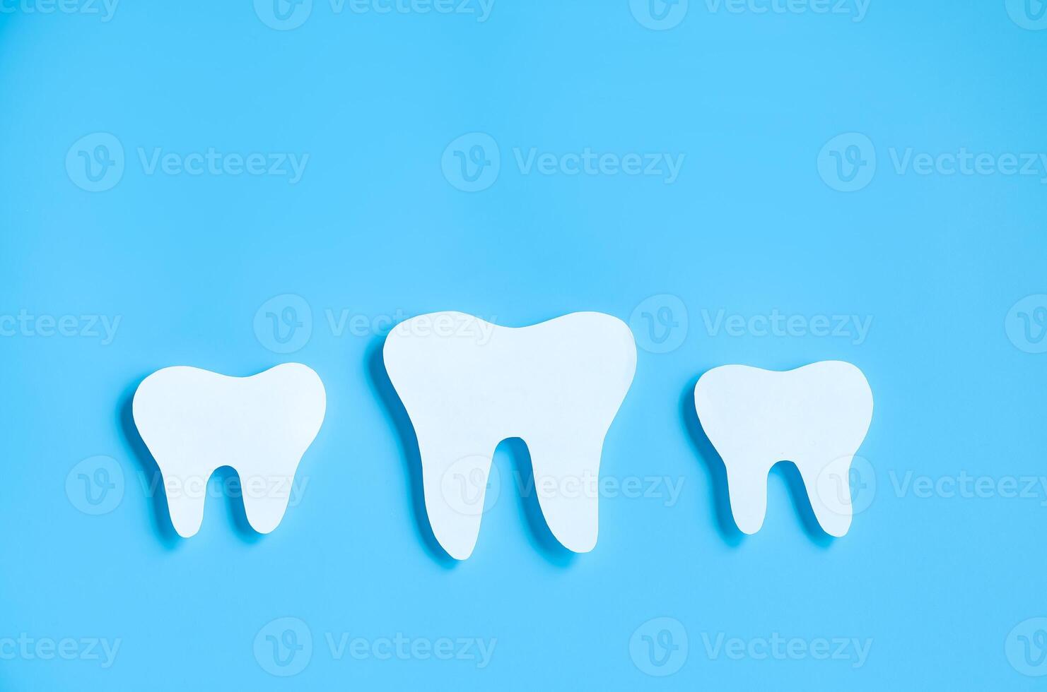 papel cortar brincar do dente em azul fundo. dental Cuidado conceito. internacional dentista dia. foto