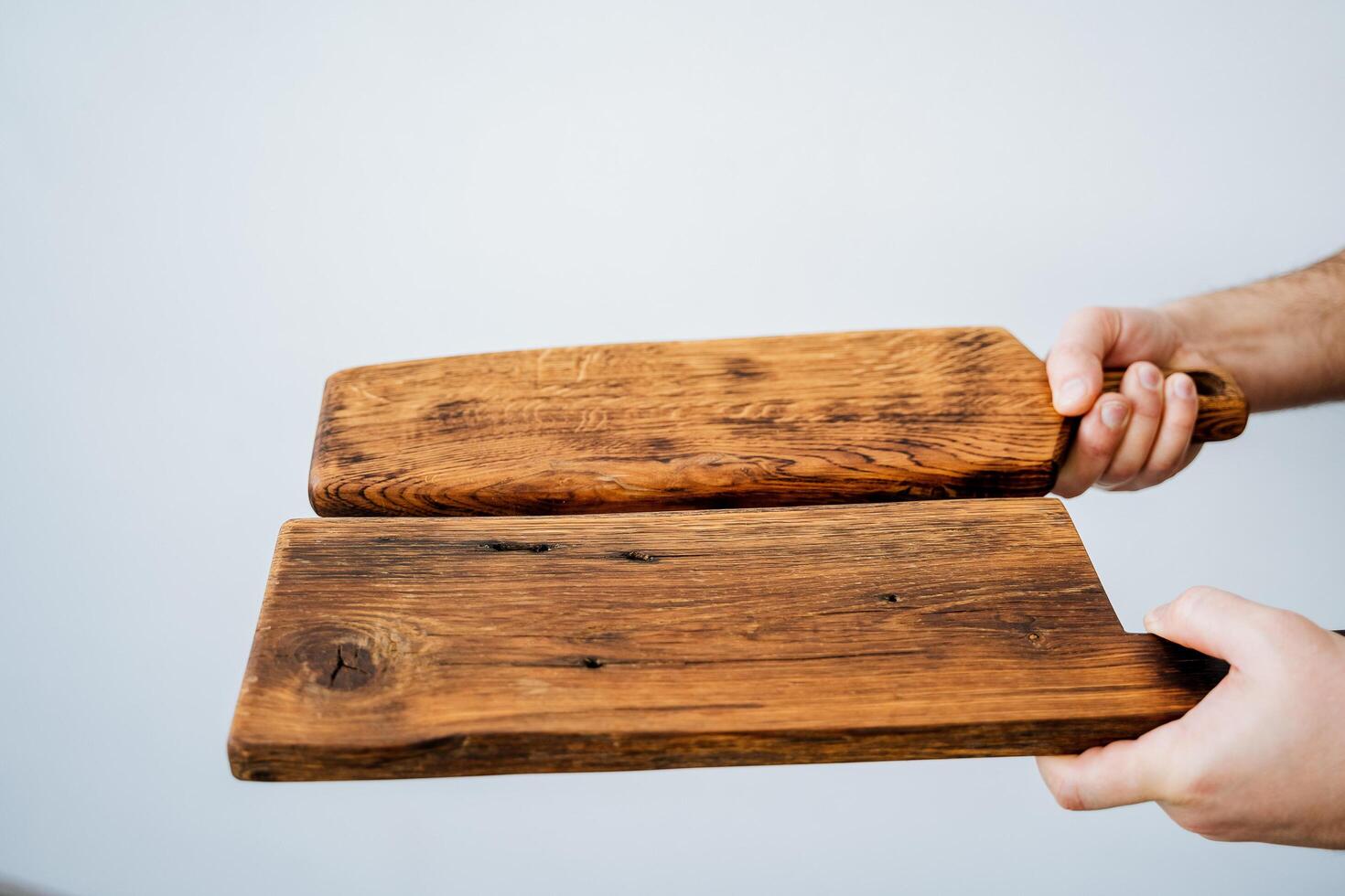 corte borda para cozinhando dentro a cozinha. uma de madeira borda dentro a mãos do uma cara. utensílios de cozinha. feito à mão carpinteiro item. foto