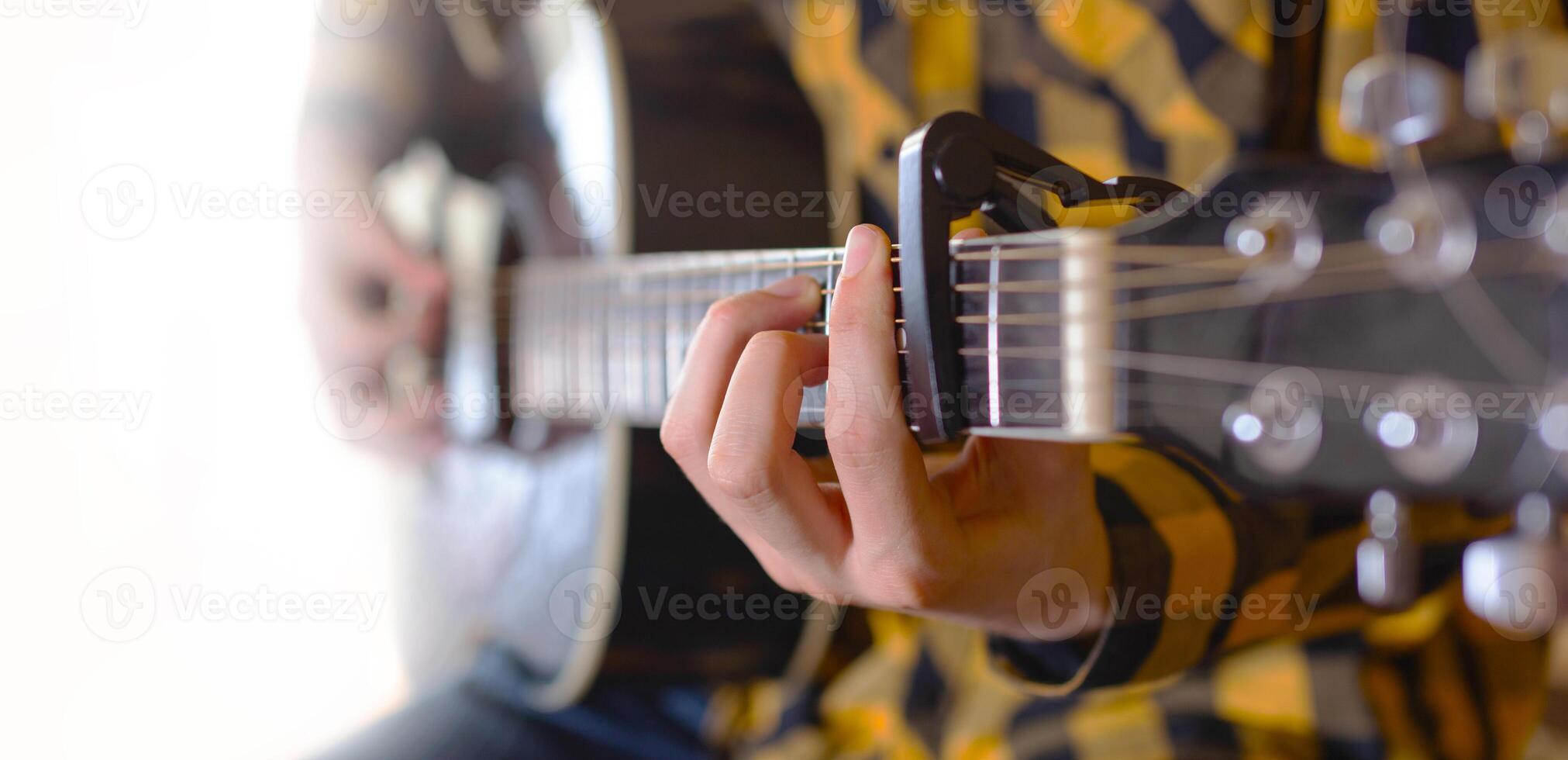 uma jovem homem jogando com acústico guitarra foto