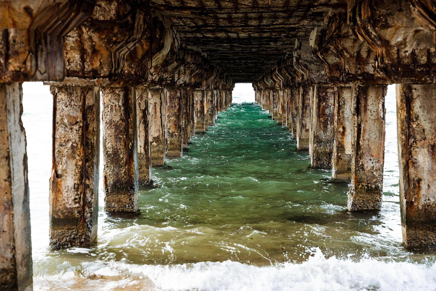 mar água debaixo a cais. uma tiro com a incrível perspectiva. brilhante verde água, puro branco mar espuma. tirar o fôlego Visualizações do natureza, de a mar foto