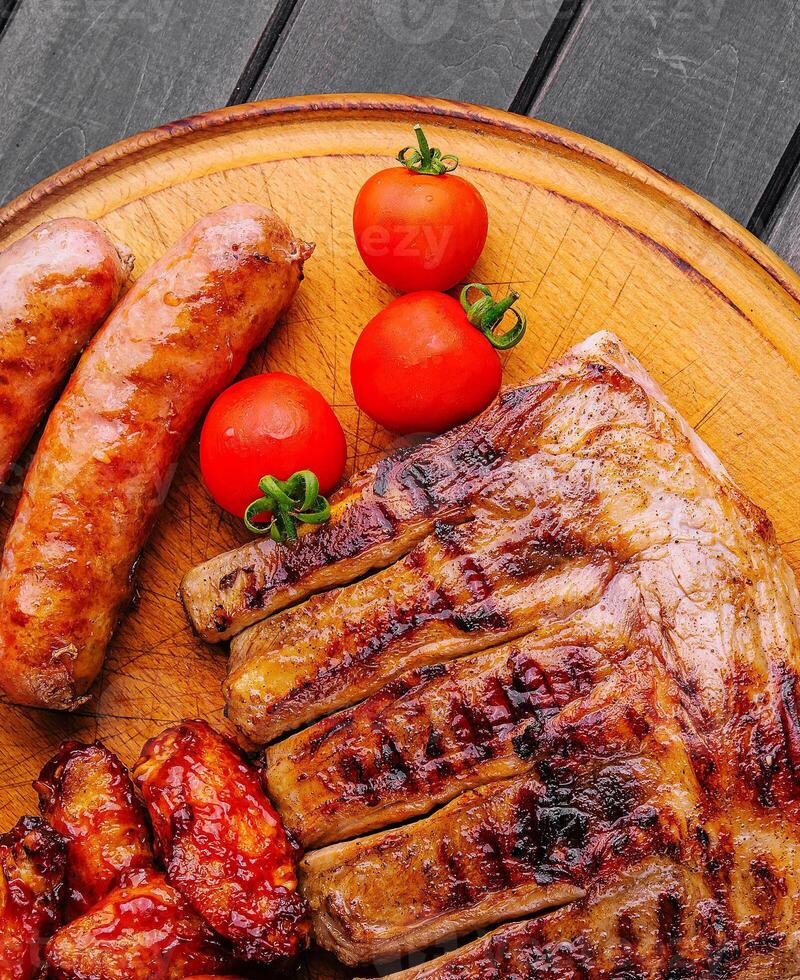 carne de porco costelas com frango e salsichas em de madeira borda foto