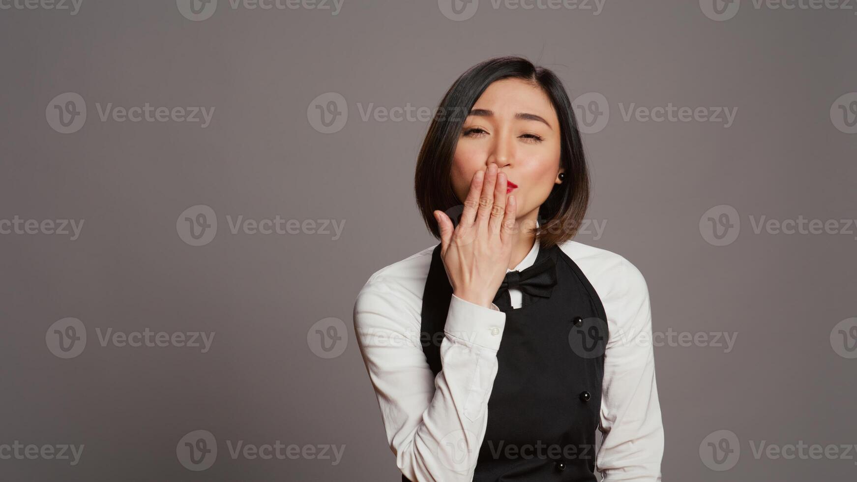 fofa provocante garçonete sopro ar Beijos dentro frente do Câmera, agindo romântico com doce gesto. ásia restaurante empregado posando com uma beijinho facial expressão, refeições indústria. Câmera b. foto