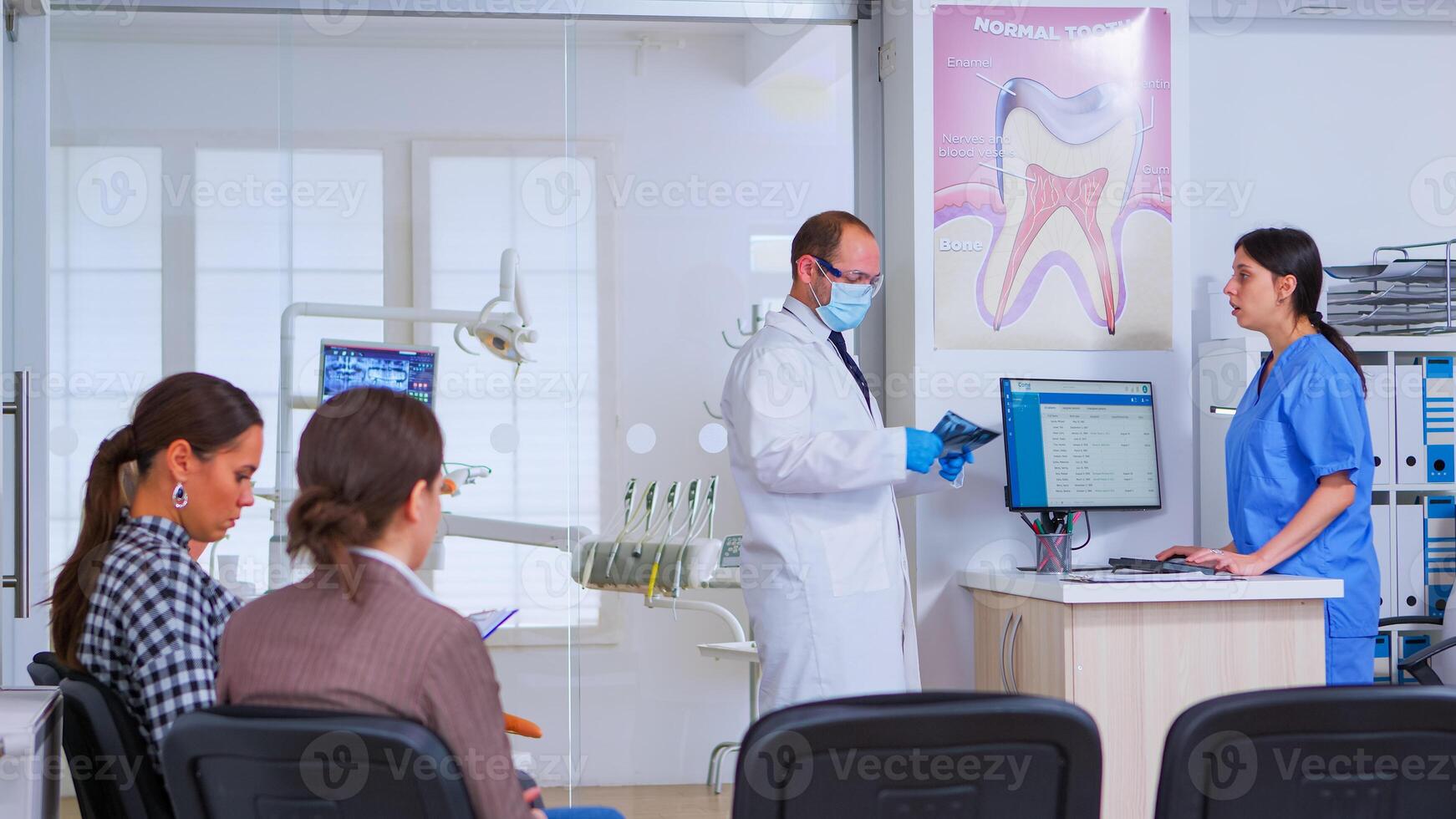 dentista acabamento com velho homem, Perguntando enfermeira para Próximo dental radiografia durante pacientes esperando. ortodontista e enfermeira trabalhando dentro lotado moderno estomatológico clínica, estomatologista olhando às raio X foto