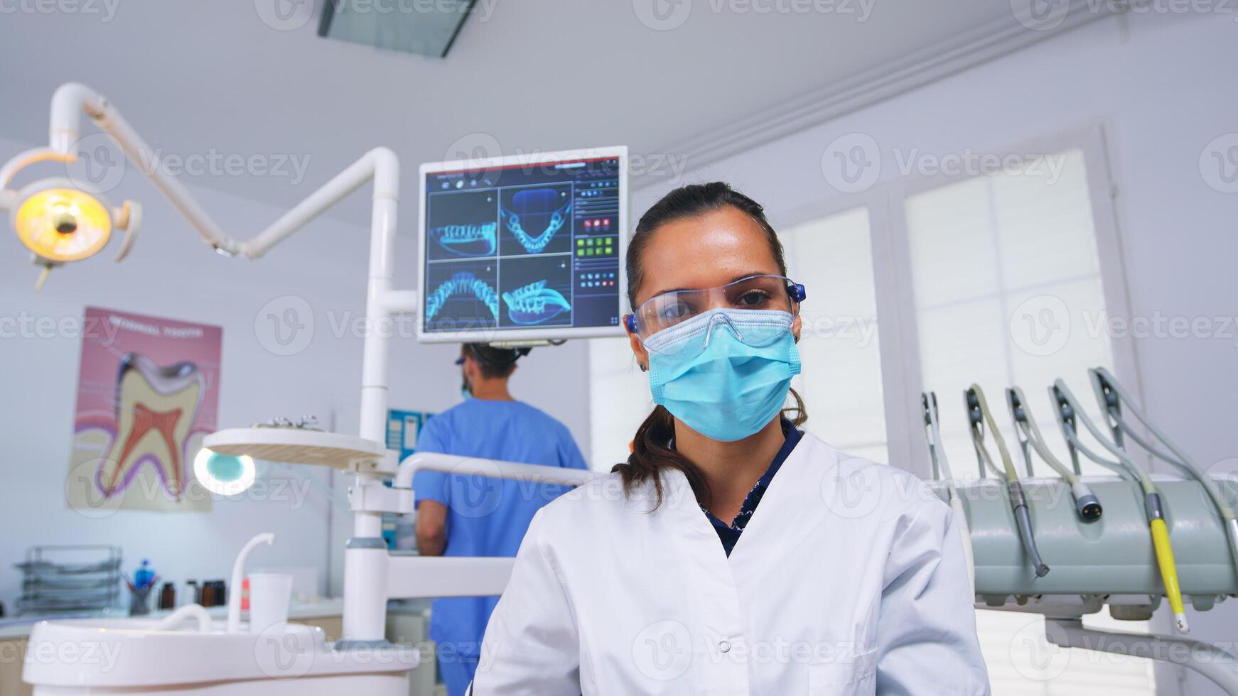 paciente pov para estomatologista colocando oxigênio mascarar antes dente cirurgia sentado em estomatológico cadeira. médico e enfermeira trabalhando dentro moderno ortodôntico escritório vestindo proteção mascarar e luvas foto