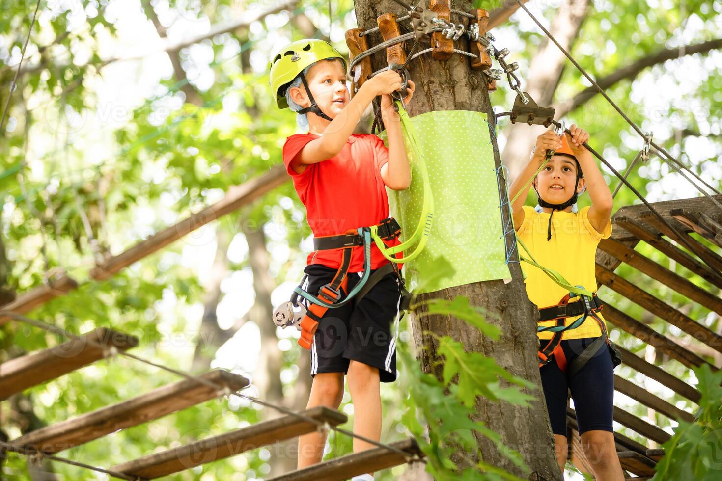 criança dentro floresta aventura parque. crianças escalar em Alto corda trilha. agilidade e escalada ao ar livre diversão Centro para crianças. pequeno menina jogando ao ar livre. escola Jardim Parque infantil com corda caminho. foto