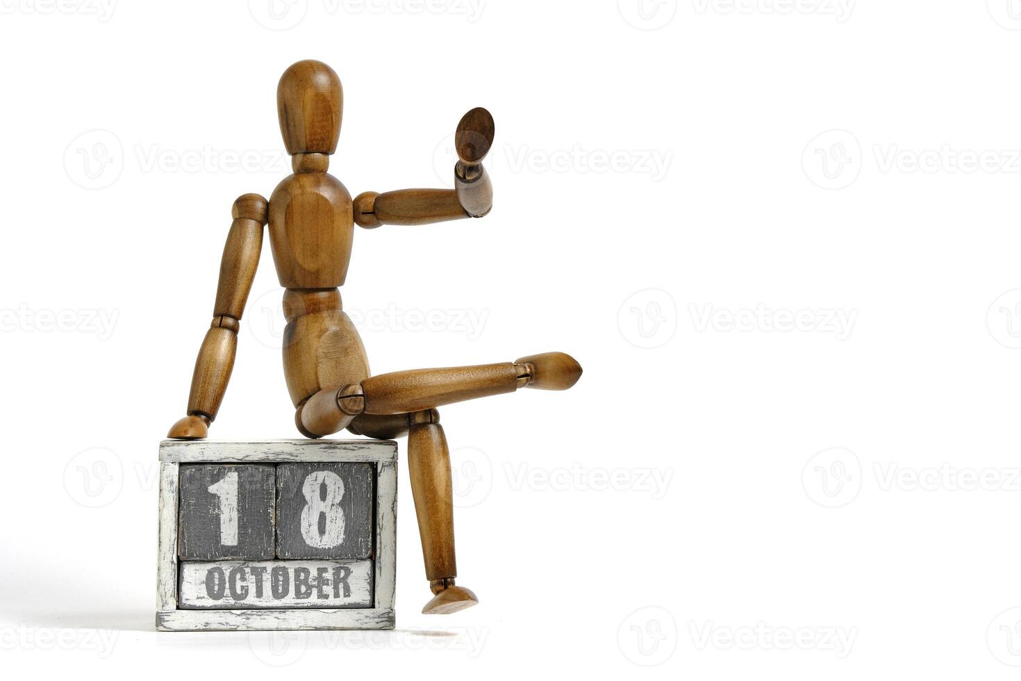 Outubro 18, de madeira calendário com manequim sentado em isto em branco fundo. calendário data. foto