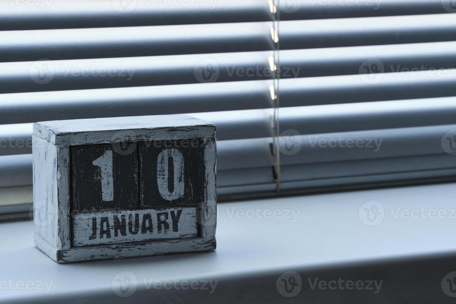 manhã janeiro 10 em de madeira calendário em pé em janela com persianas. foto