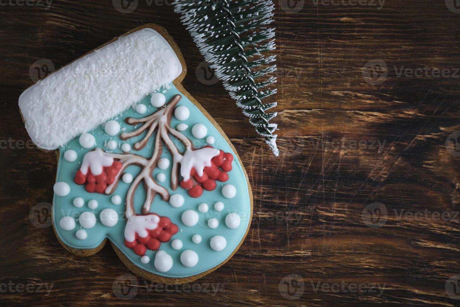 caprichoso luva em forma Natal biscoitos, Rowan árvore glacê, Nevado acentos, em uma rústico de madeira pano de fundo. foto