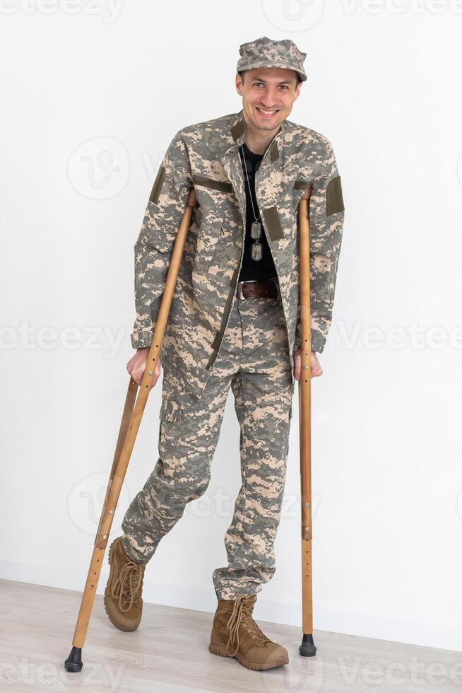retrato do soldado com muletas contra branco fundo foto