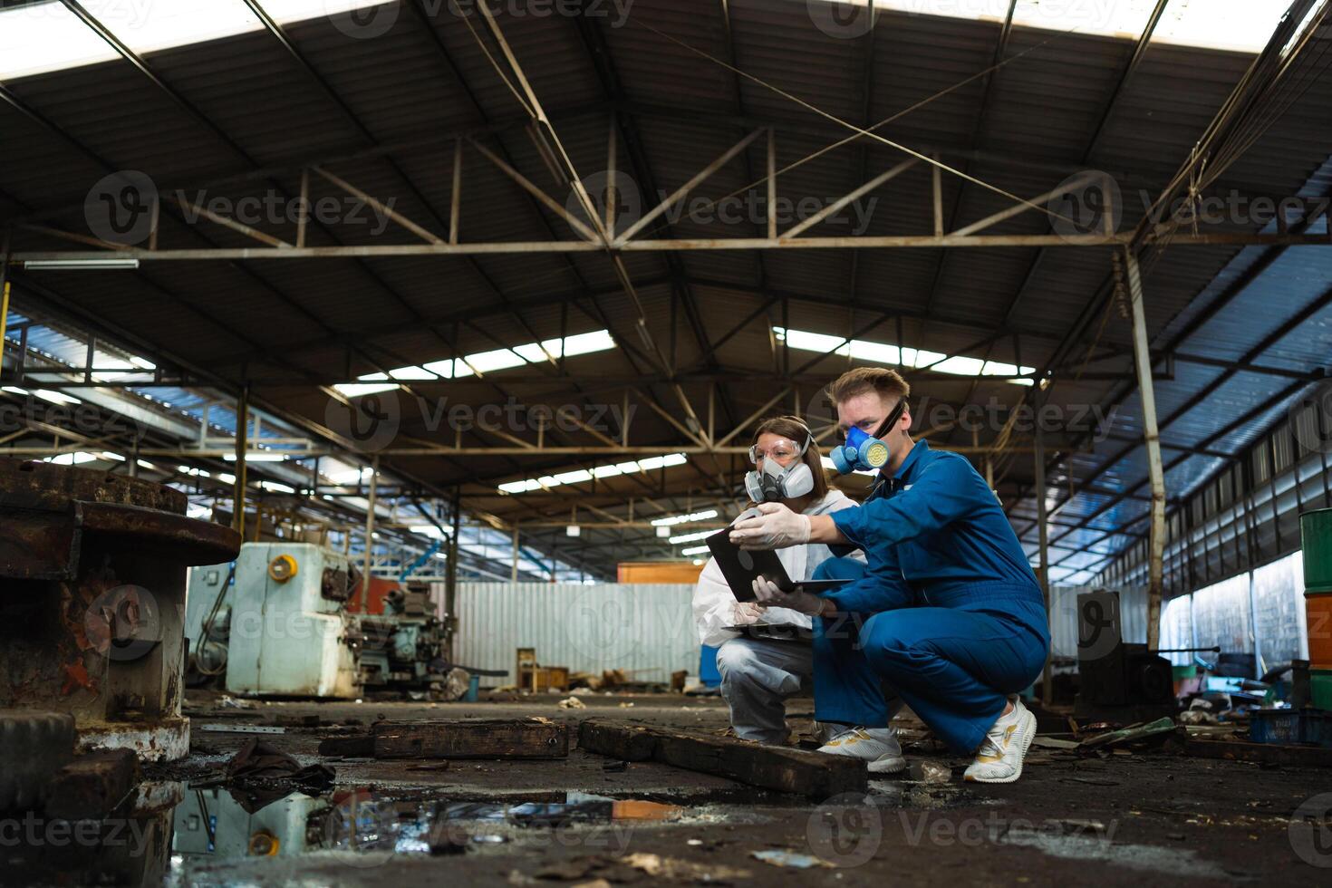 uma equipe do engenheiros vestindo segurança ternos e gás máscaras é debaixo inspeção do uma químico tanque às a industrial local. foto