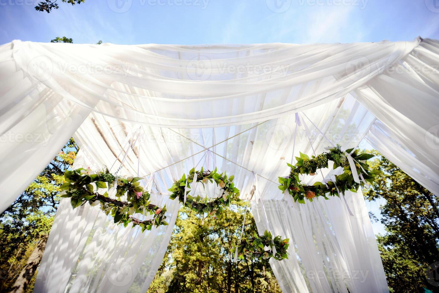 lindo Casamento arco para a cerimônia dentro a jardim dentro ensolarado clima foto