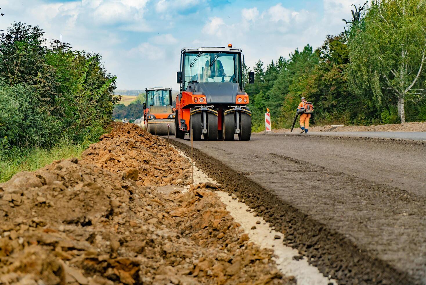 vista de perto sobre os rolos compactadores trabalhando no novo canteiro de obras rodoviárias. pavimentação de estrada foto