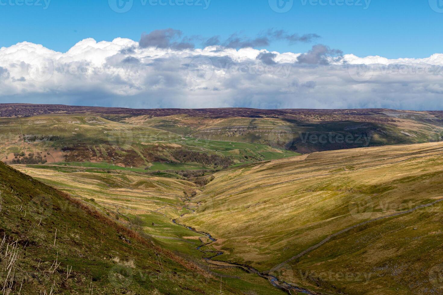 rolando colinas com verde vales debaixo uma nublado azul céu, exibindo natural beleza e sereno paisagens dentro yorkshire vales. foto