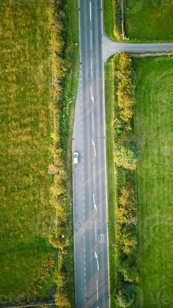 aéreo Visão do uma carro dirigindo em uma rural estrada com verde Campos em qualquer lado dentro Iorque. foto