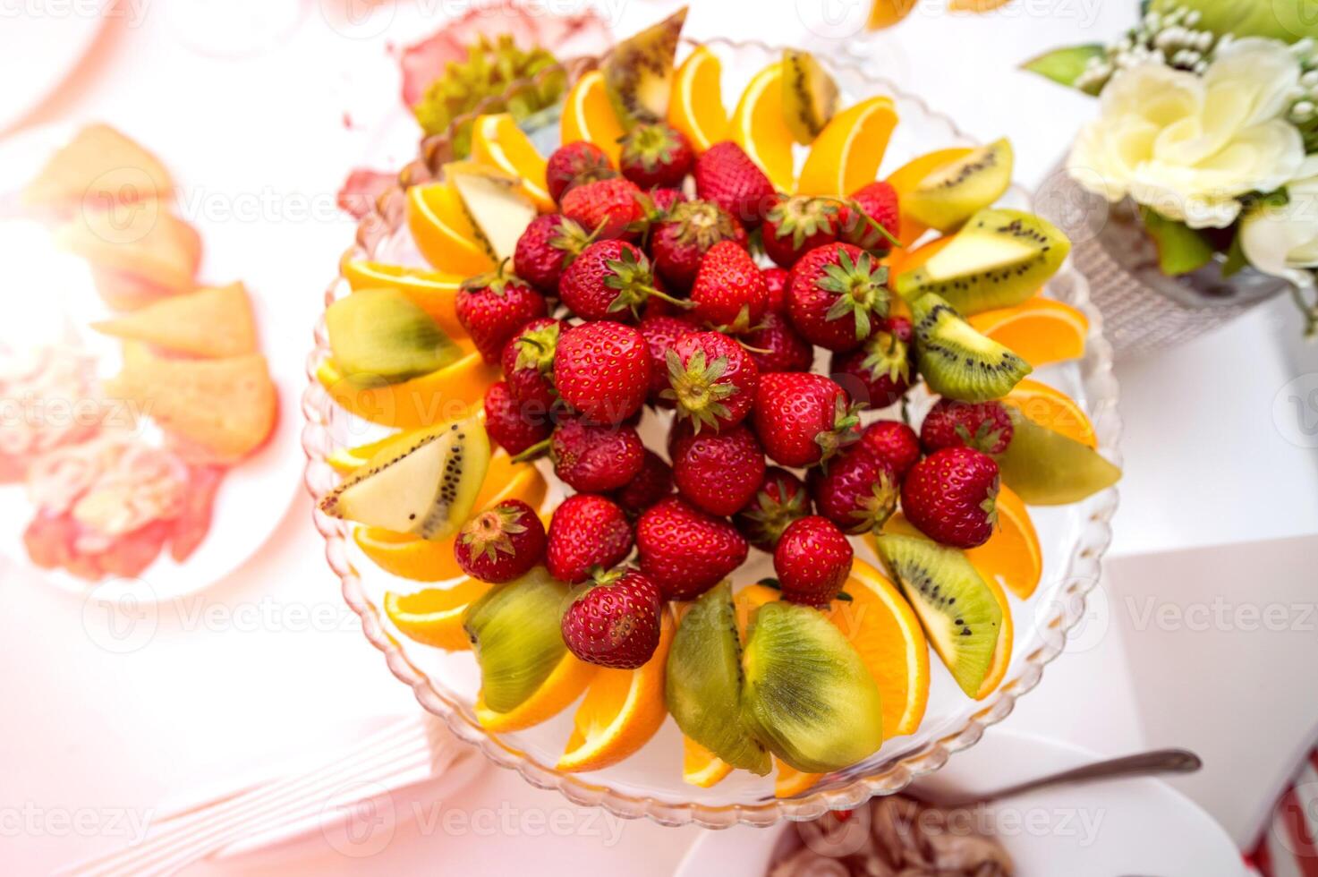 delicioso frutas dentro prato em uma festivo mesa. saudável fresco fruta prato com morangos, laranjas e kiwis em uma Casamento mesa. fechar-se foto