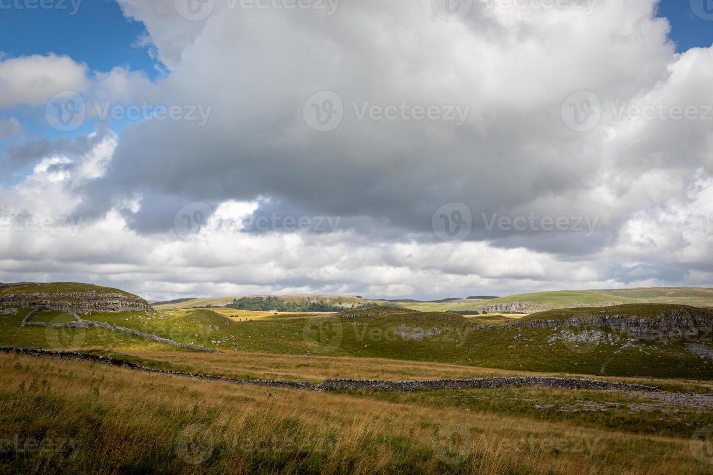 rolando colinas debaixo uma dramático nublado céu, exibindo a natural beleza do uma sereno panorama. foto