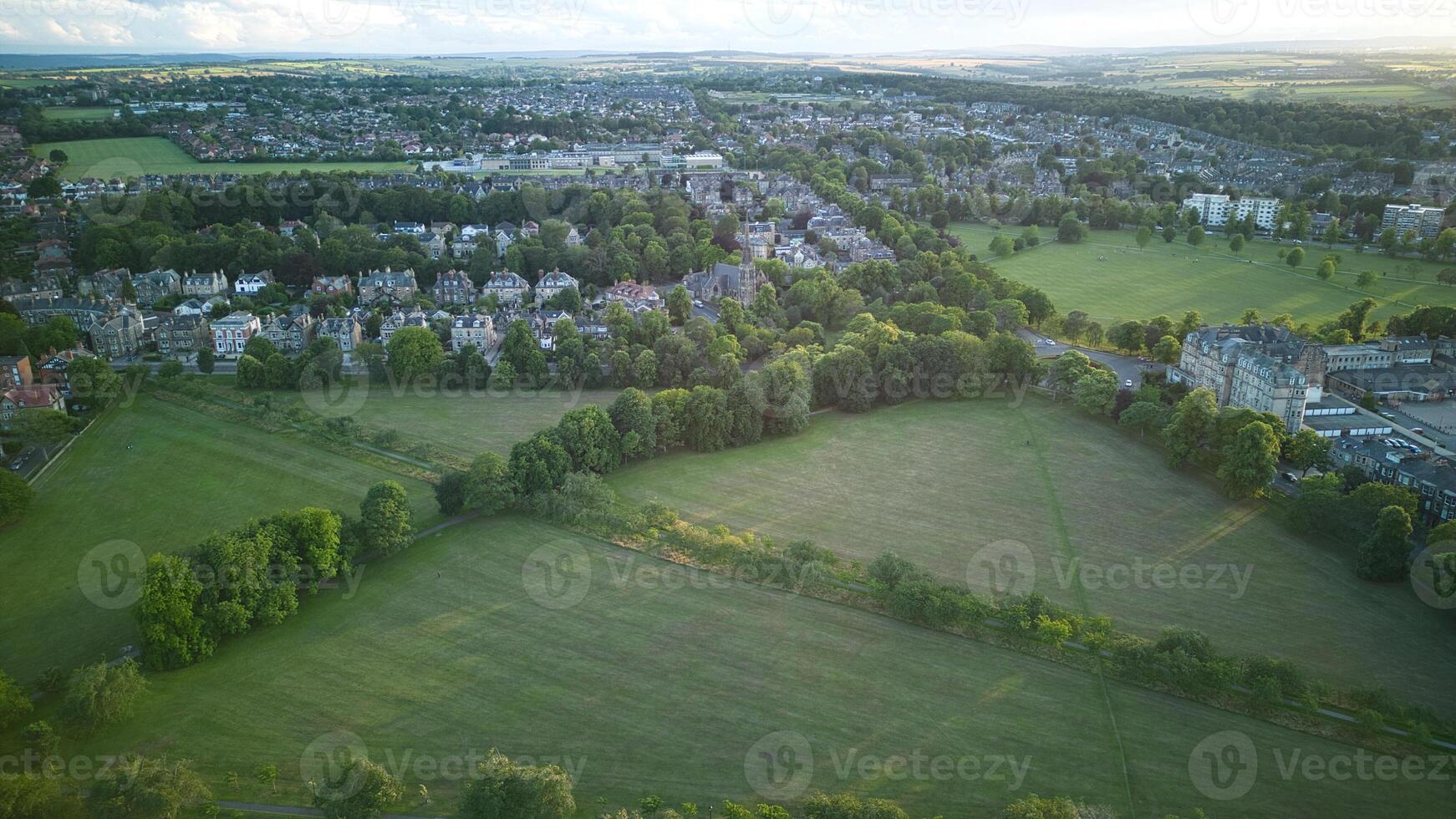 aéreo Visão do uma verde suburbano panorama às crepúsculo com residencial casas e aberto Campos dentro Harrogate, norte Iorque. foto