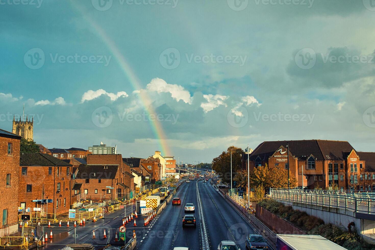 urbano panorama com arco Iris sobre cidade rua e histórico edifícios às pôr do sol. foto