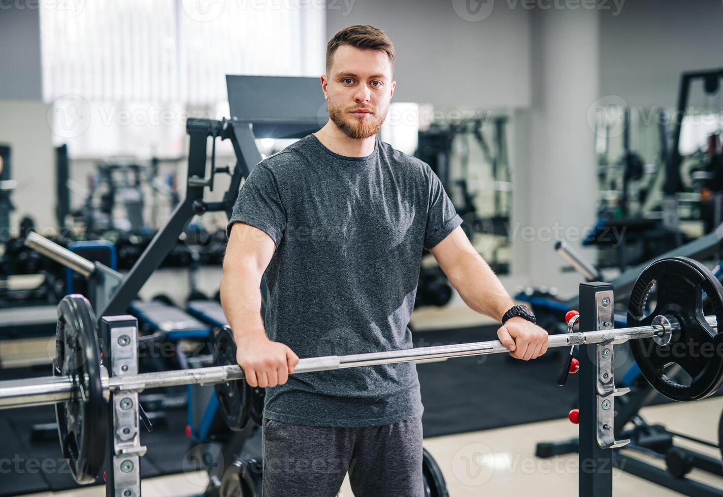 à moda bonito treinador dentro moderno academia. atraente jovem homem esperando para trem às academia. foto