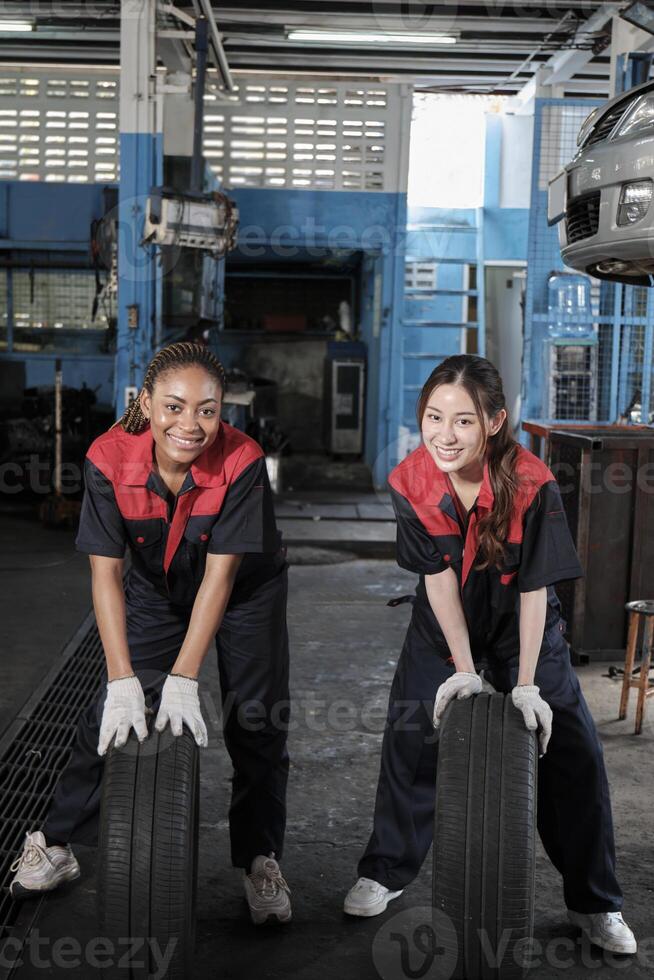 dois diverso fêmea automotivo mecânico trabalhador parceiros competir para empurrar carro rodas para mudança e reparar às garagem, veículo manutenção serviço empregos, indústria ocupação, e profissional trabalho trabalho foto