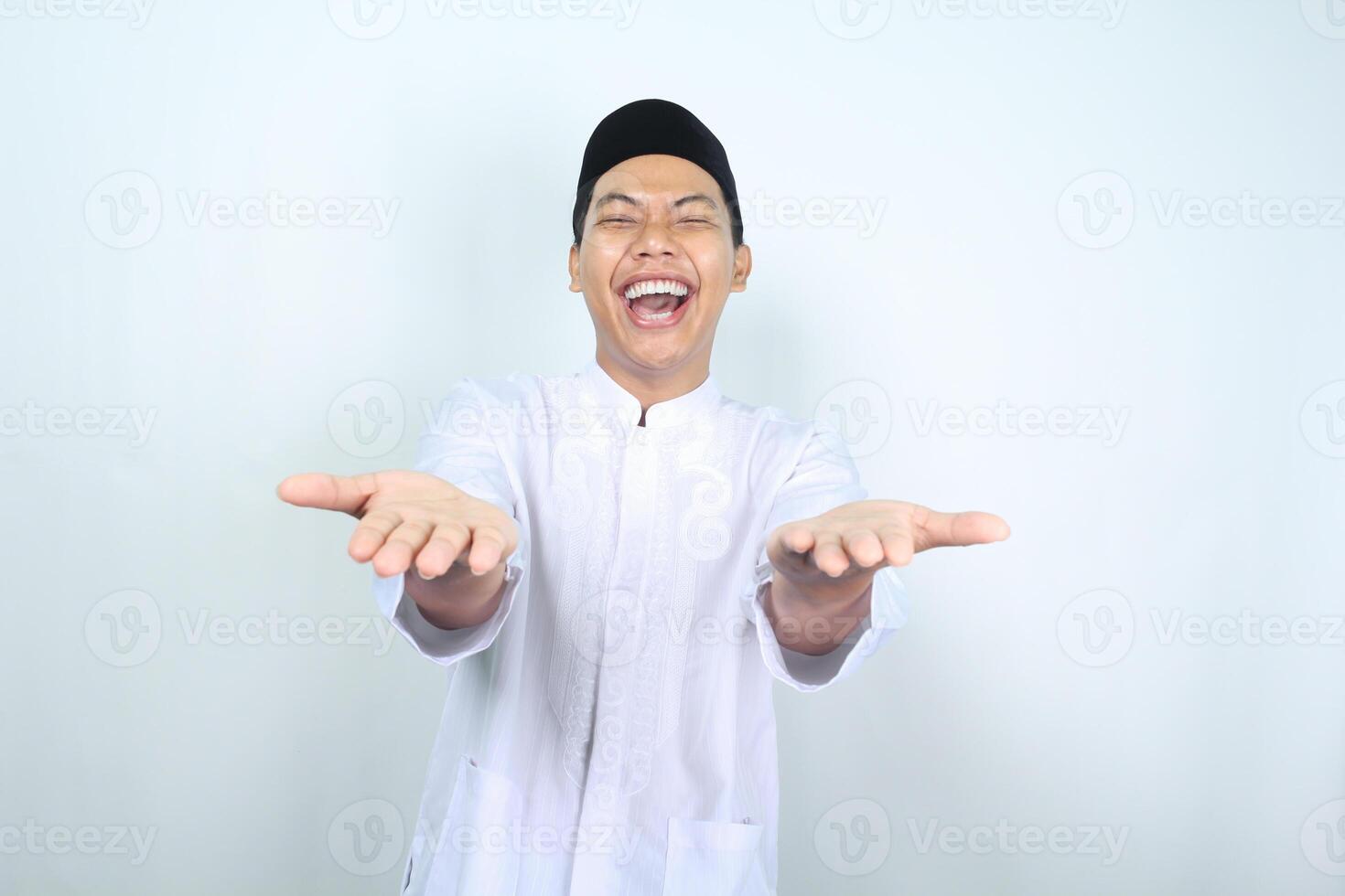 retrato do rindo ásia muçulmano homem apresentando braço frente para Câmera isolado em branco fundo foto