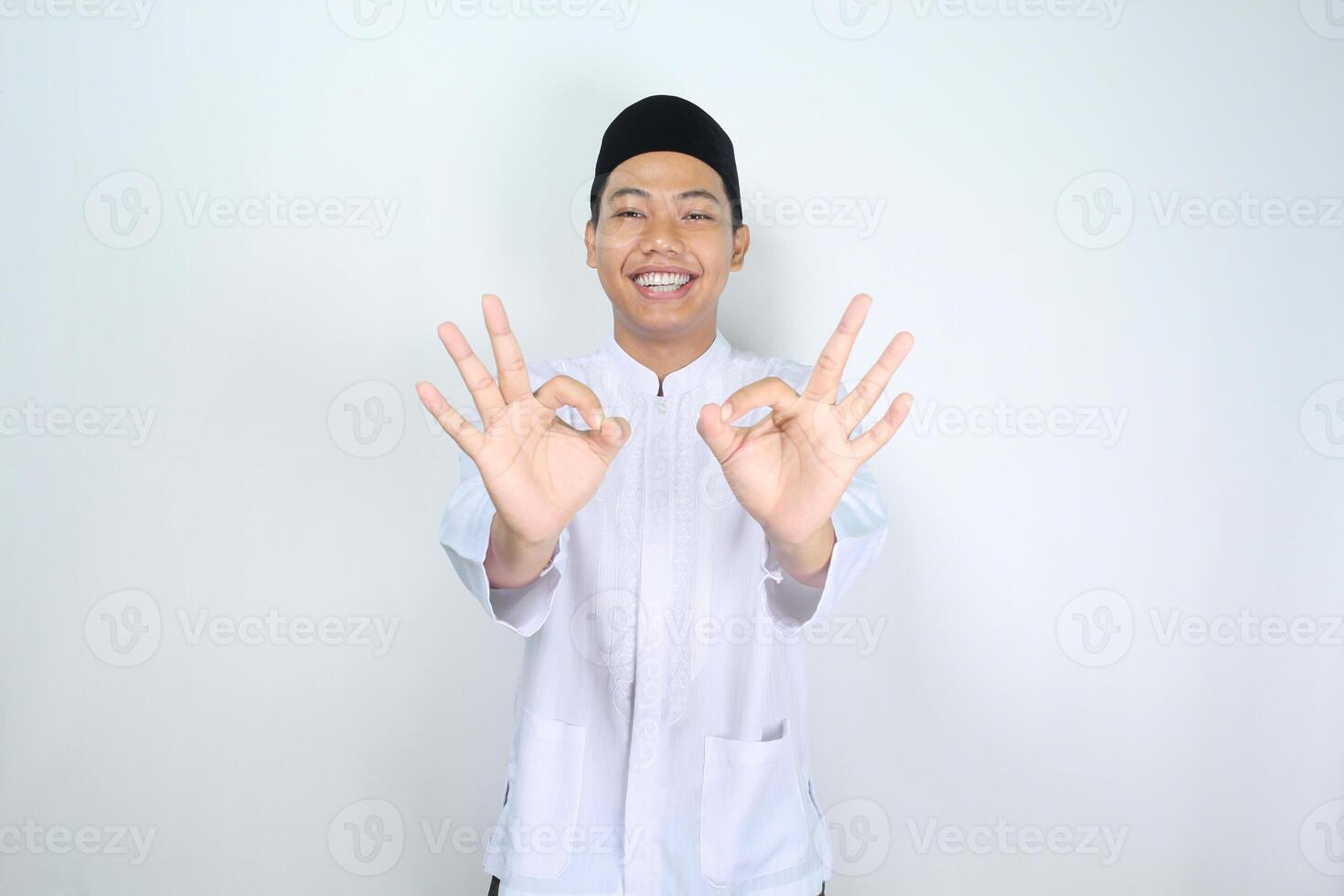 sorridente ásia homem muçulmano mostrar Está bem sinais isolado em branco fundo foto