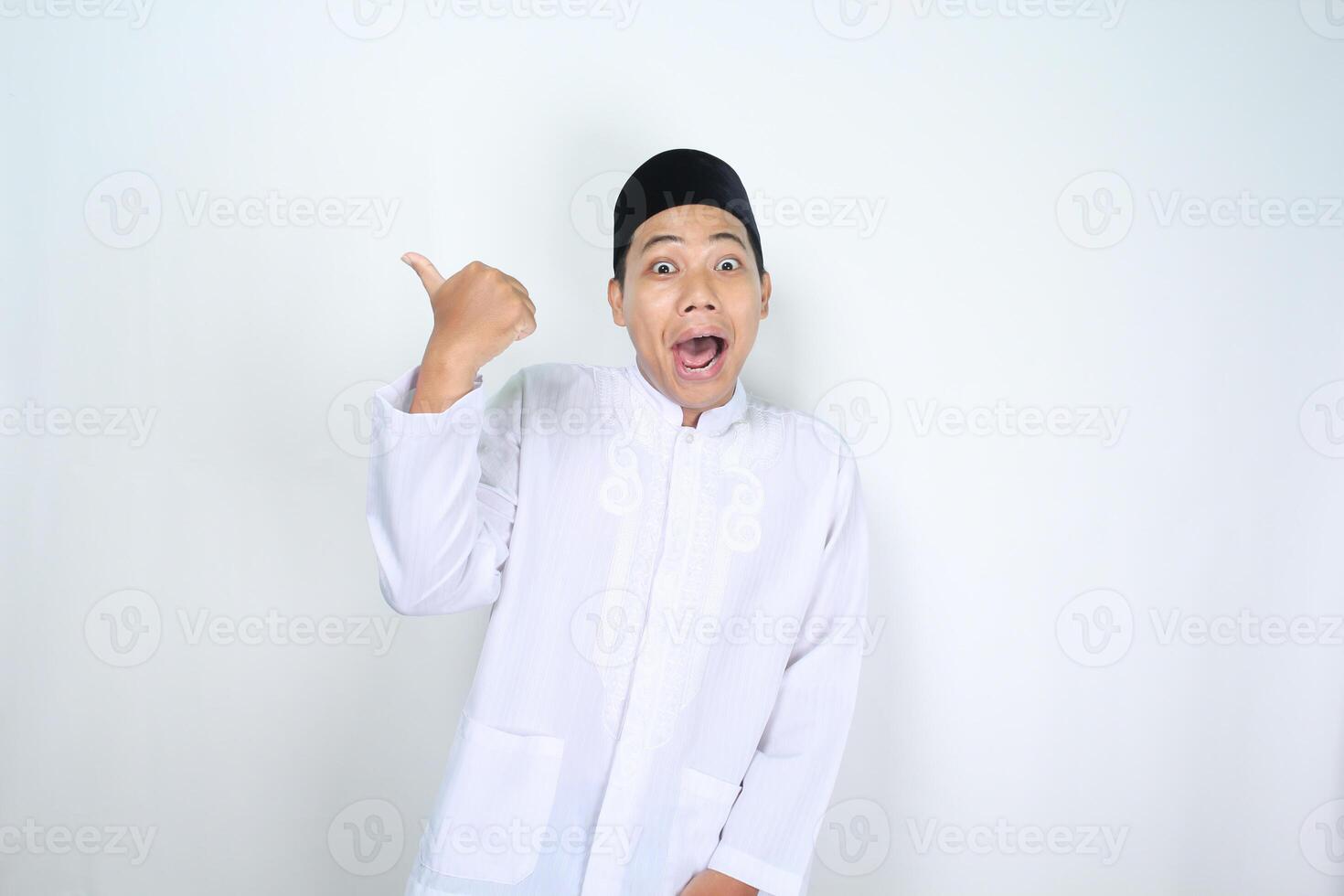 engraçado ásia muçulmano homem dando polegares acima com surpreso expressão isolado em branco fundo foto