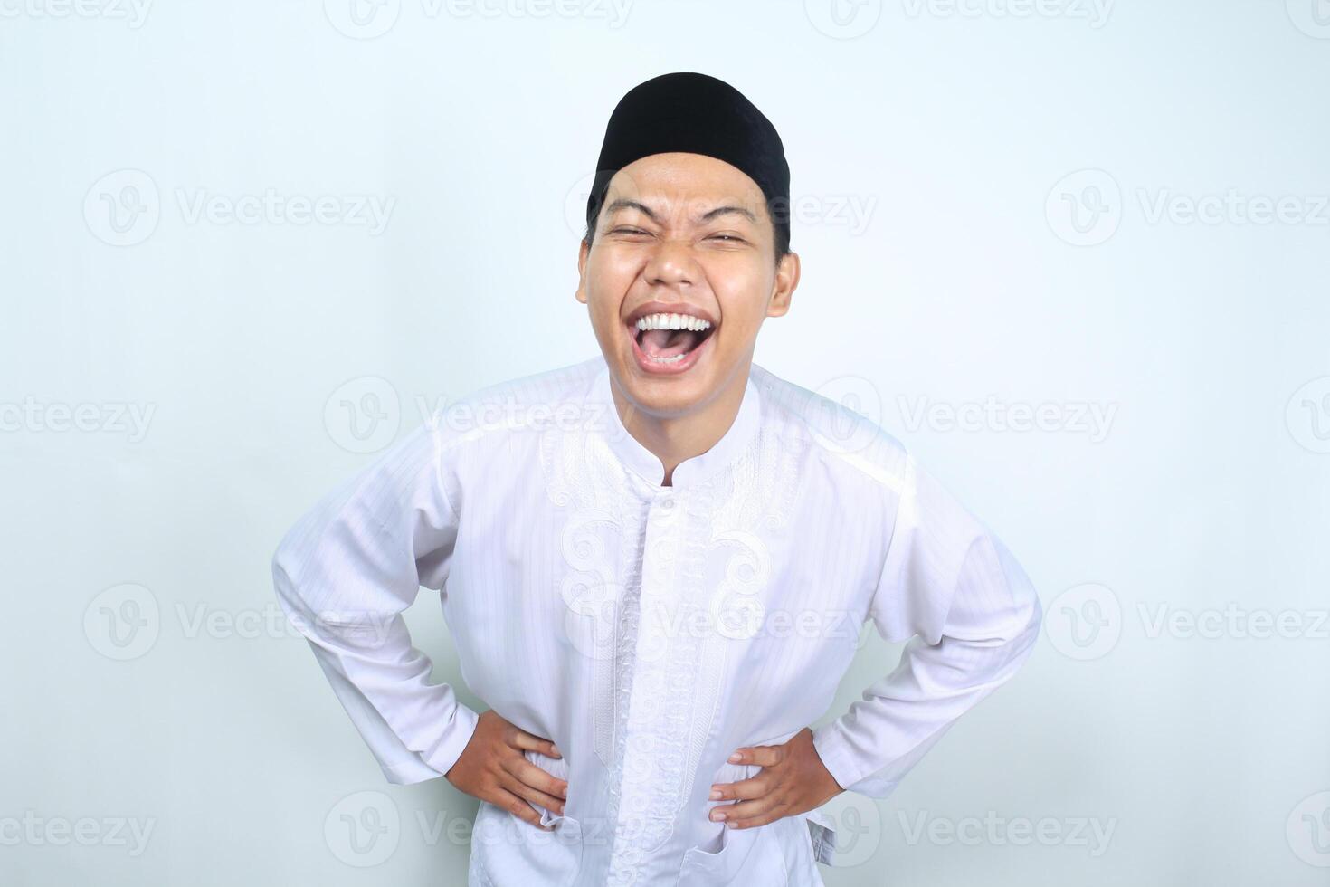 em êxtase ásia muçulmano homem rindo com mão em cintura isolado em branco fundo foto
