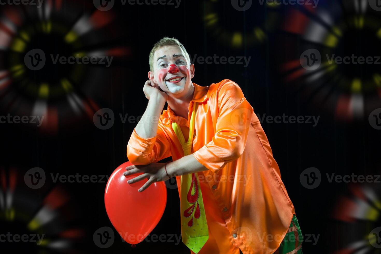 uma homem dentro uma palhaço equipamento com uma balão foto