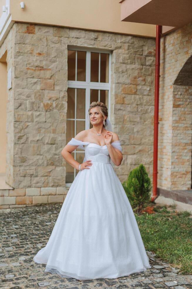 lindo noiva dentro uma branco Casamento vestir. uma jovem noiva menina é caminhando dentro natureza em uma verão dia. verão casamento. foto