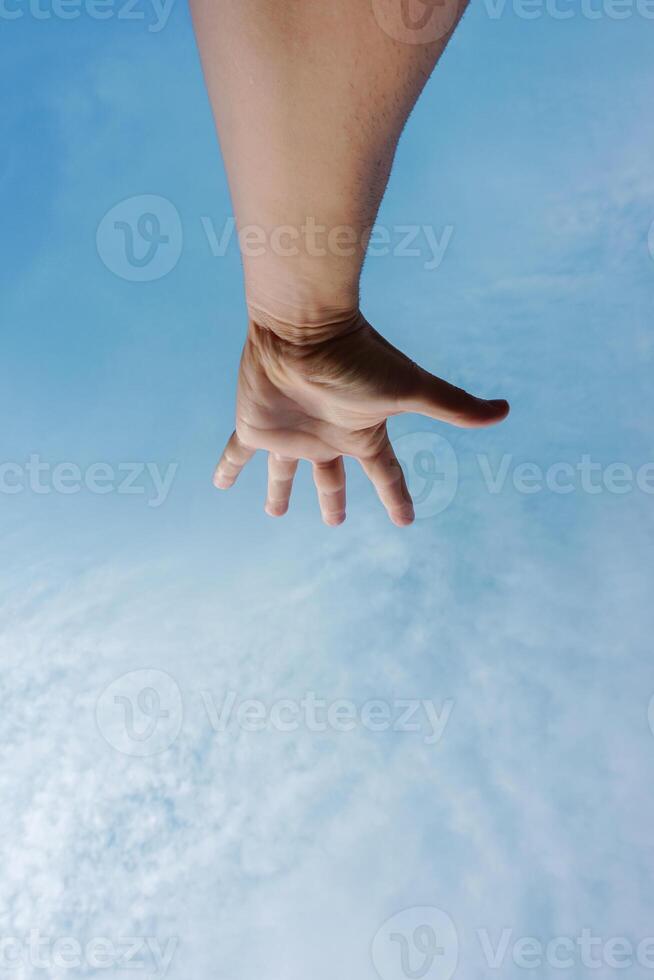 homem mão gesticulando e alcançando a azul céu foto