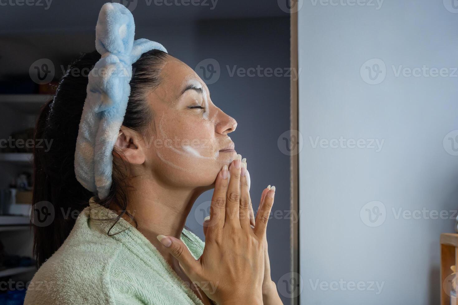 latim menina aplica-se facial limpeza espuma às noite foto