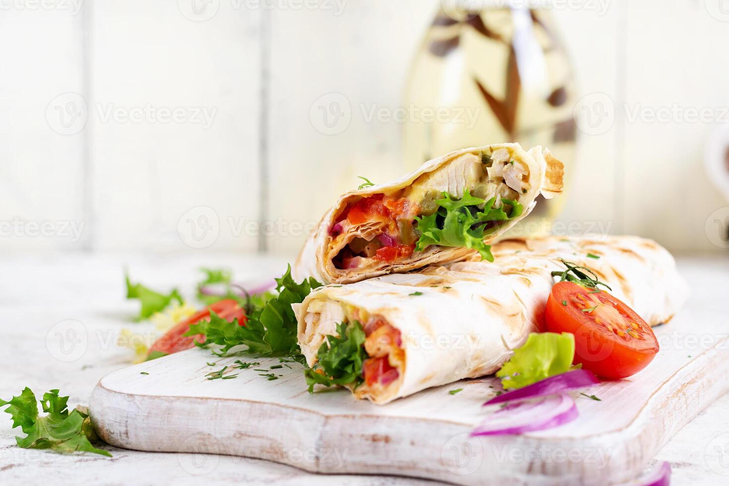 grelhado tortilla envoltórios com frango e fresco legumes em branco de madeira borda. frango burrito. mexicano Comida. saudável Comida conceito. foto