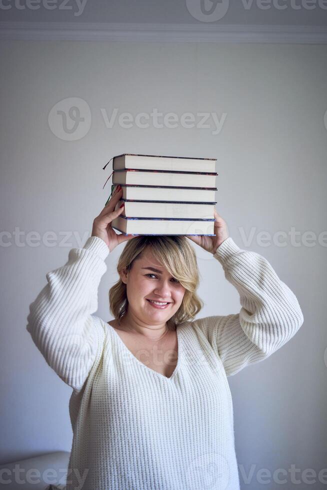 uma tamanho médio mulher dentro luz roupas tocam com livros dentro uma luz quarto foto