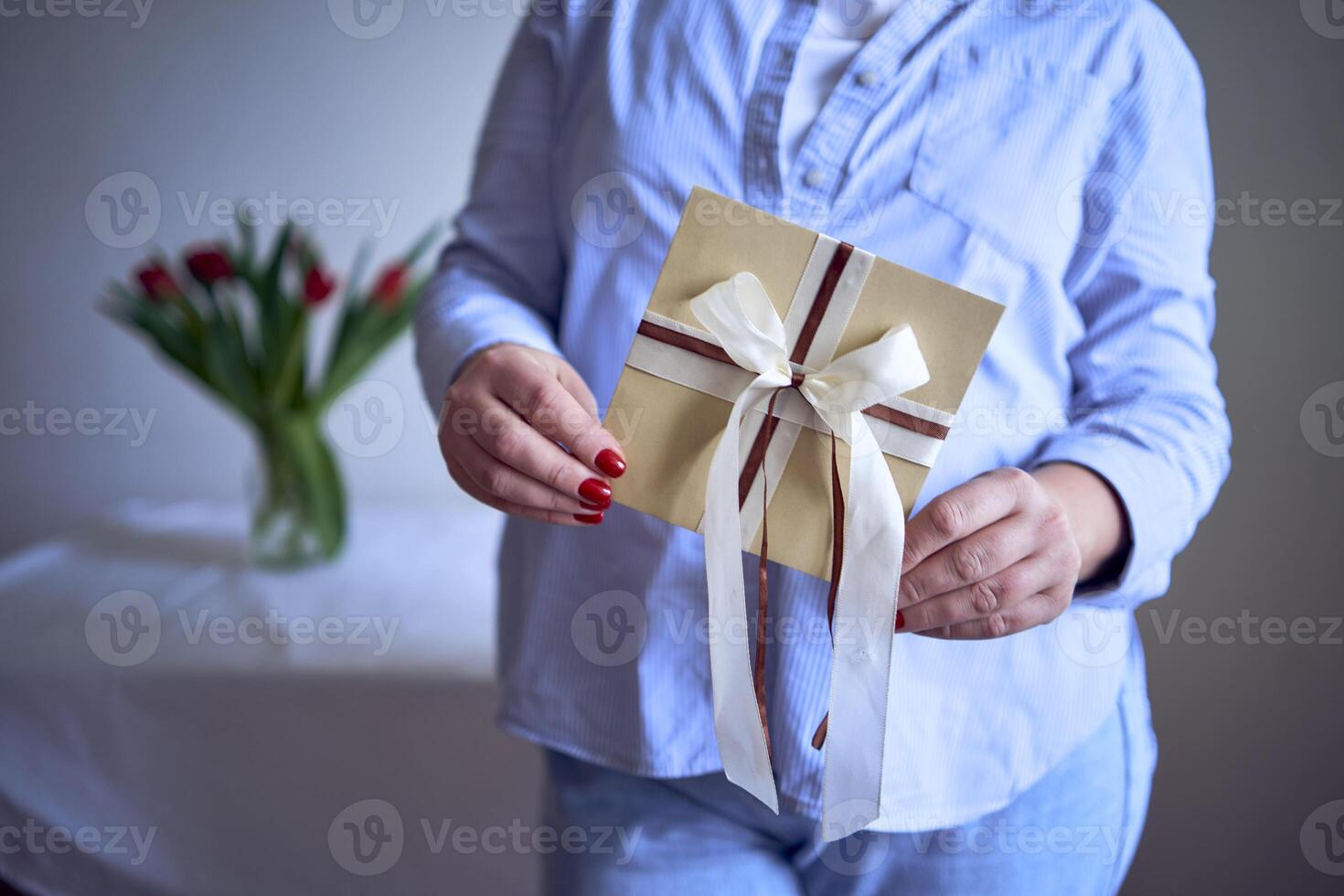 uma tamanho médio mulher detém uma construir presente certificado dentro dela mãos foto