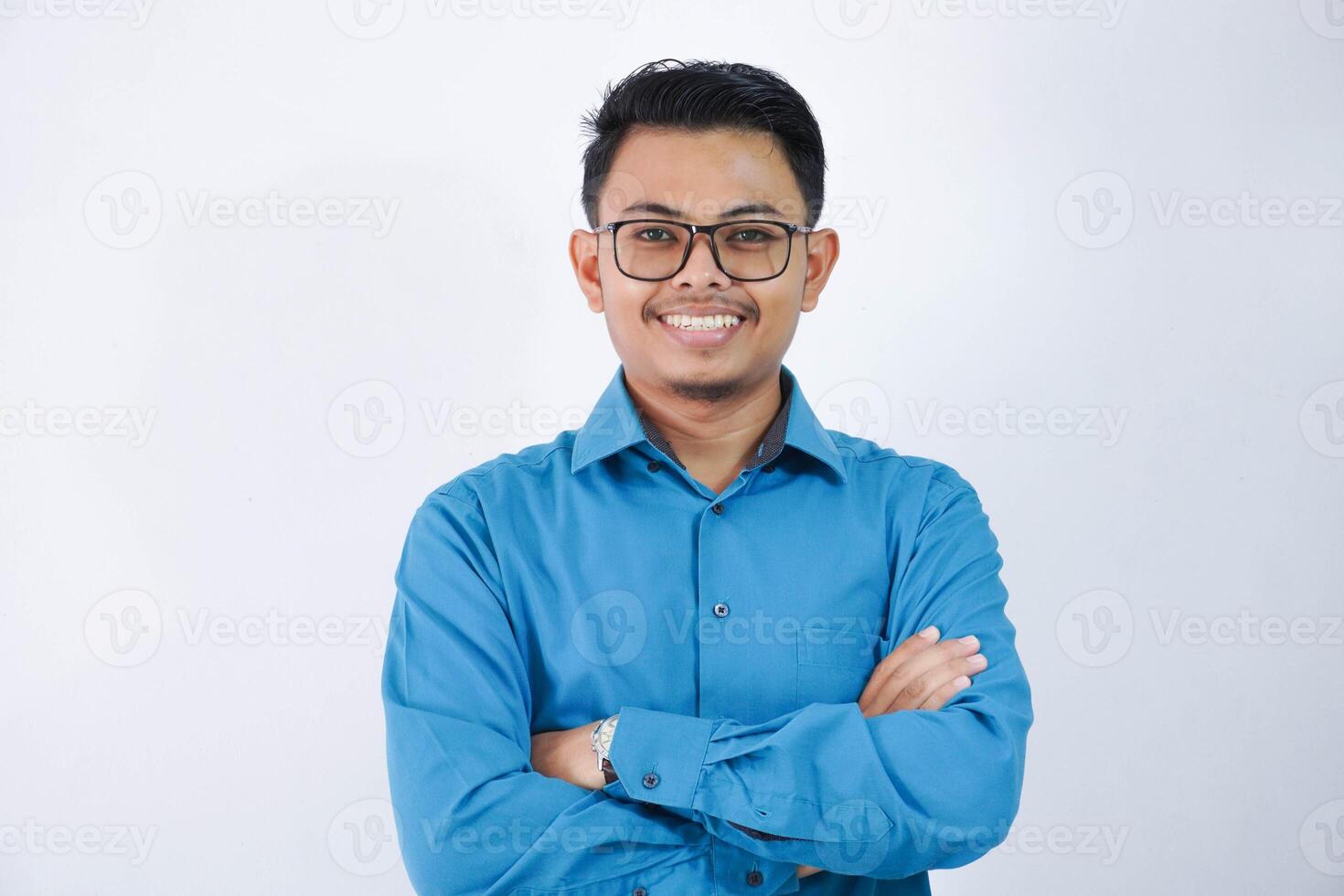 sorrir ou feliz ásia homem de negocios com óculos cruzado braços e olhando Câmera vestindo azul camisa isolado em branco fundo foto