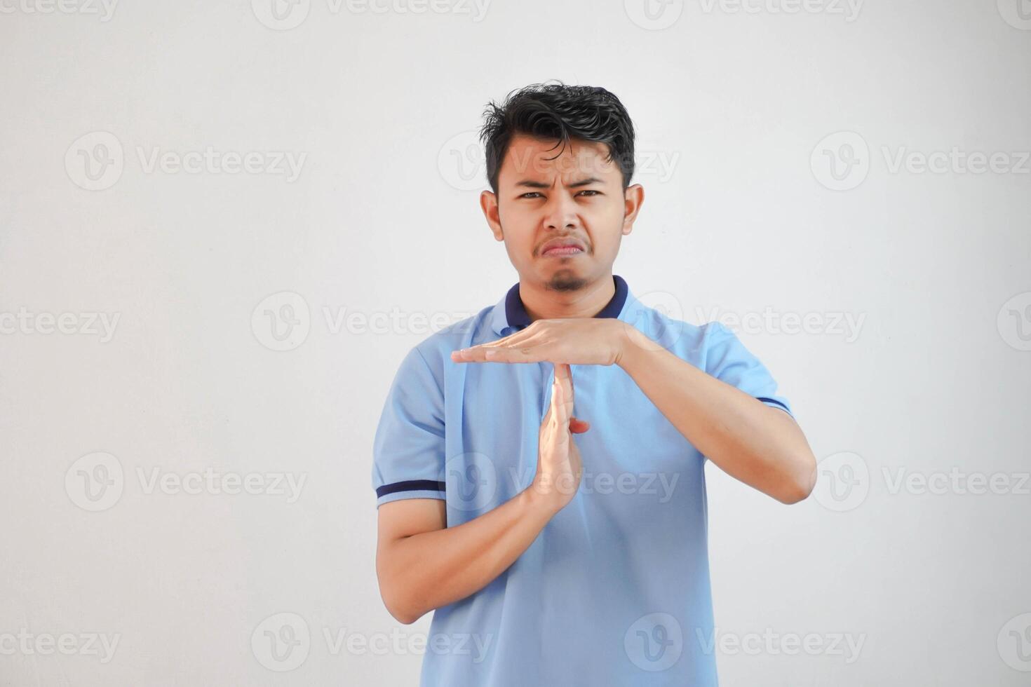 jovem ásia homem dando Tempo Fora mão gesto vestindo azul pólo t camisa isolado em branco fundo foto