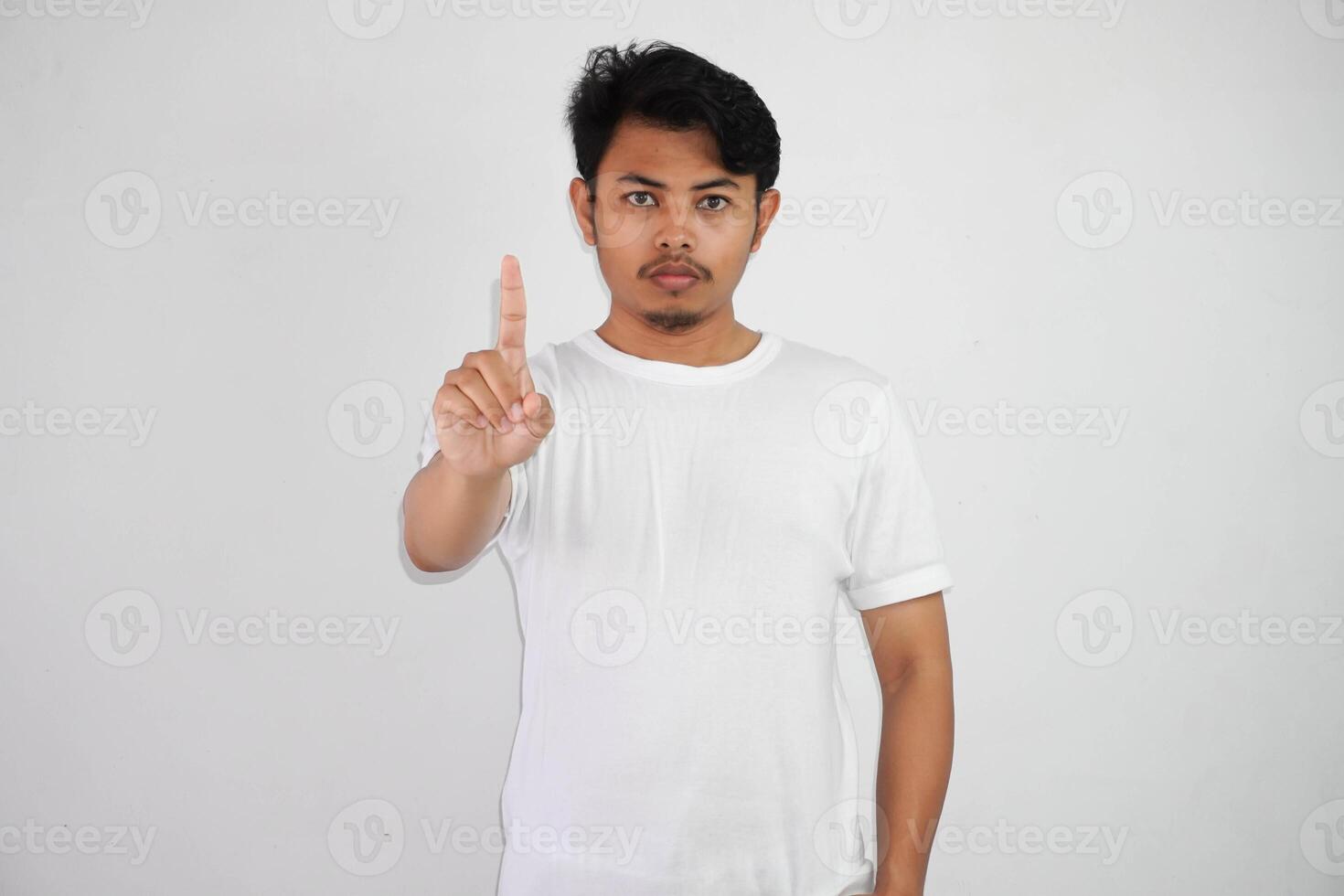 sério jovem ásia homem mostrando Pare gesto, demonstrando negação placa vestindo branco t camisa isolado em branco fundo foto