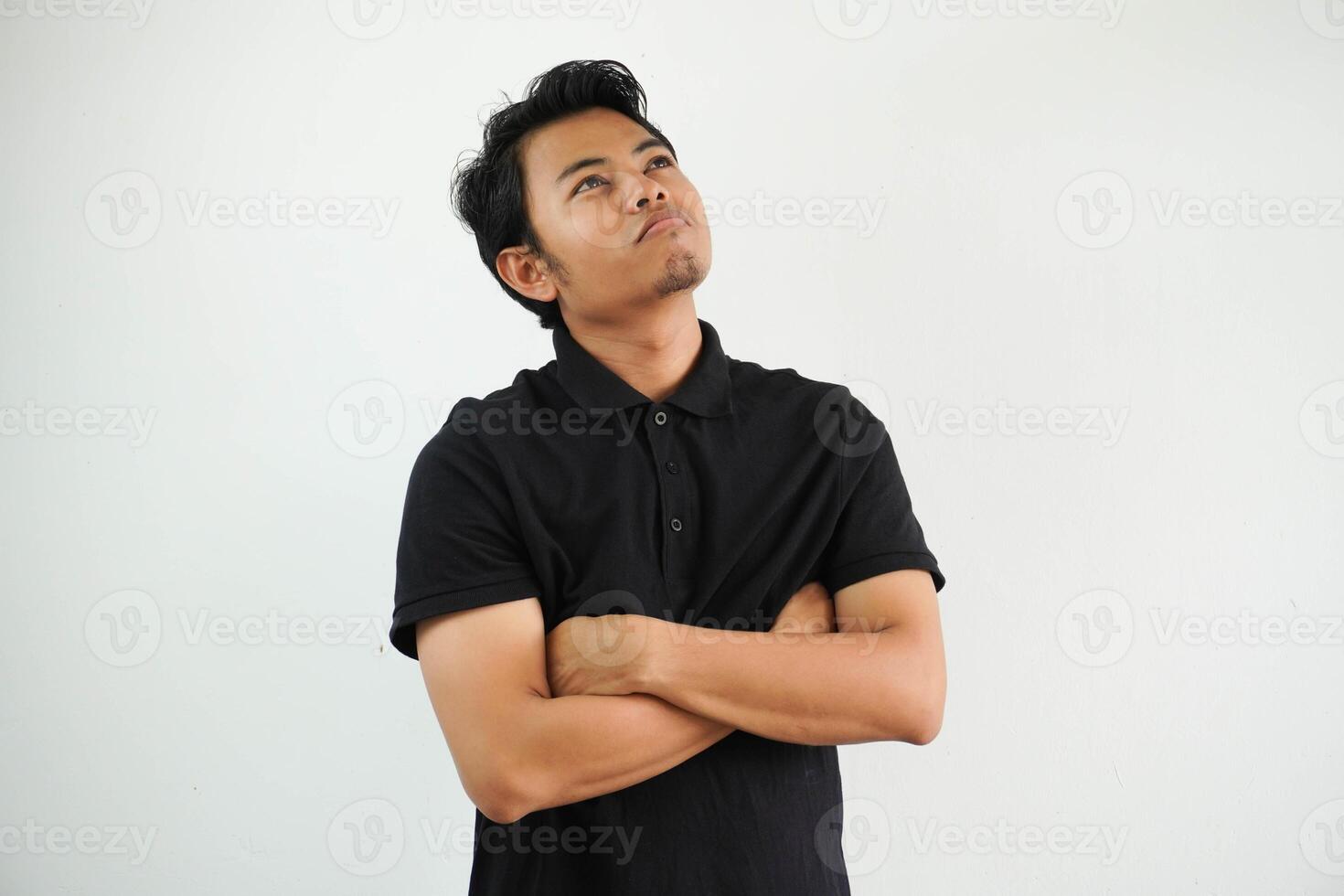 jovem ásia homem dentro casual Preto pólo t camisa com braço cruzado cansado do uma repetitivo tarefa olhando às Câmera estúdio tiro isolado em branco fundo foto