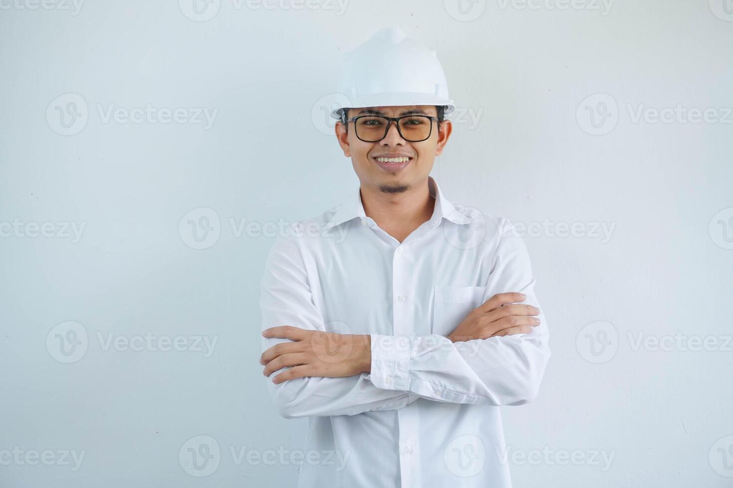 jovem ásia homem é engenheiro vestindo capacete em pé com cruzado braços e sorridente com confiante, arquiteto ou contratante, trabalhador ou trabalho, industrial conceito. foto