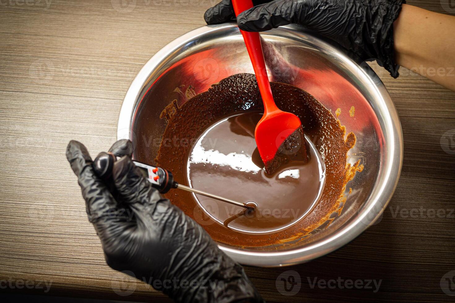 mulher cozinhando saboroso derretido chocolate em mesa dentro cozinha. foto