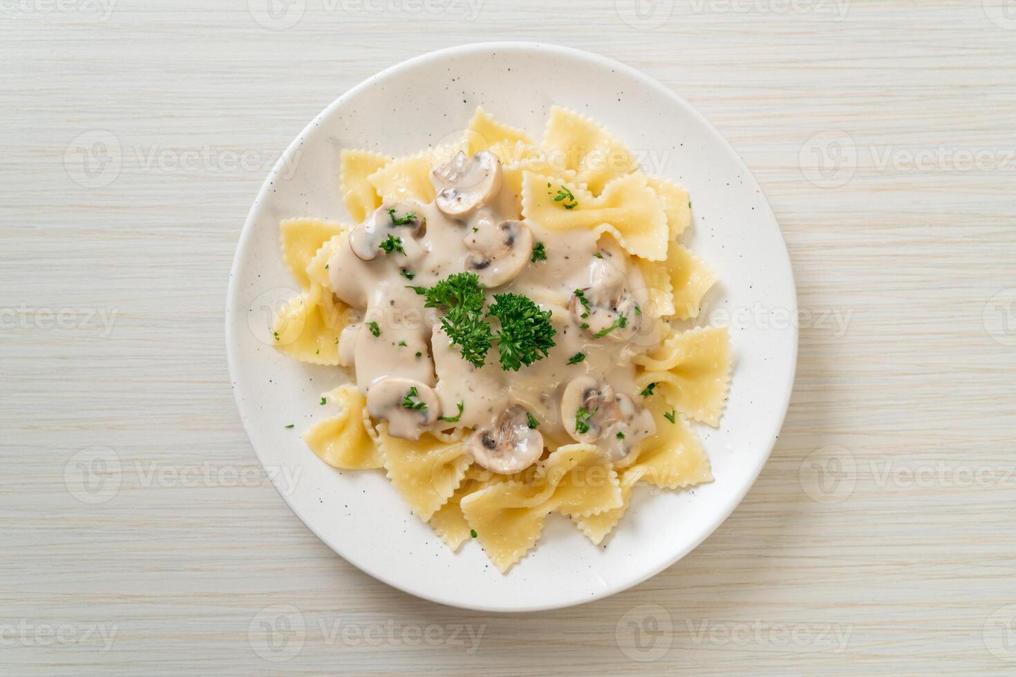 macarrão farfalle com molho de creme de cogumelos branco foto